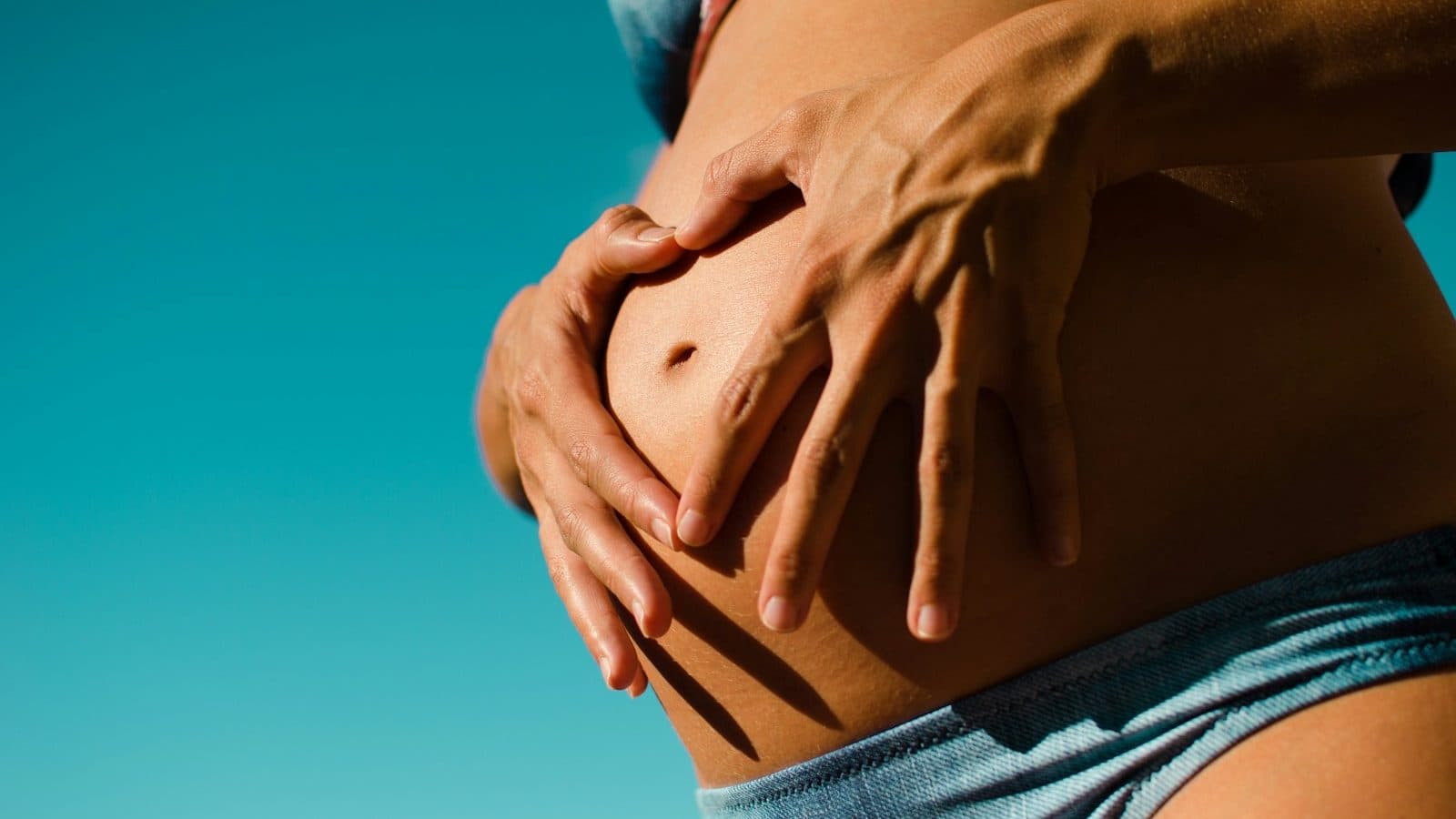 closeup photography of pregnant woman wearing blue panty