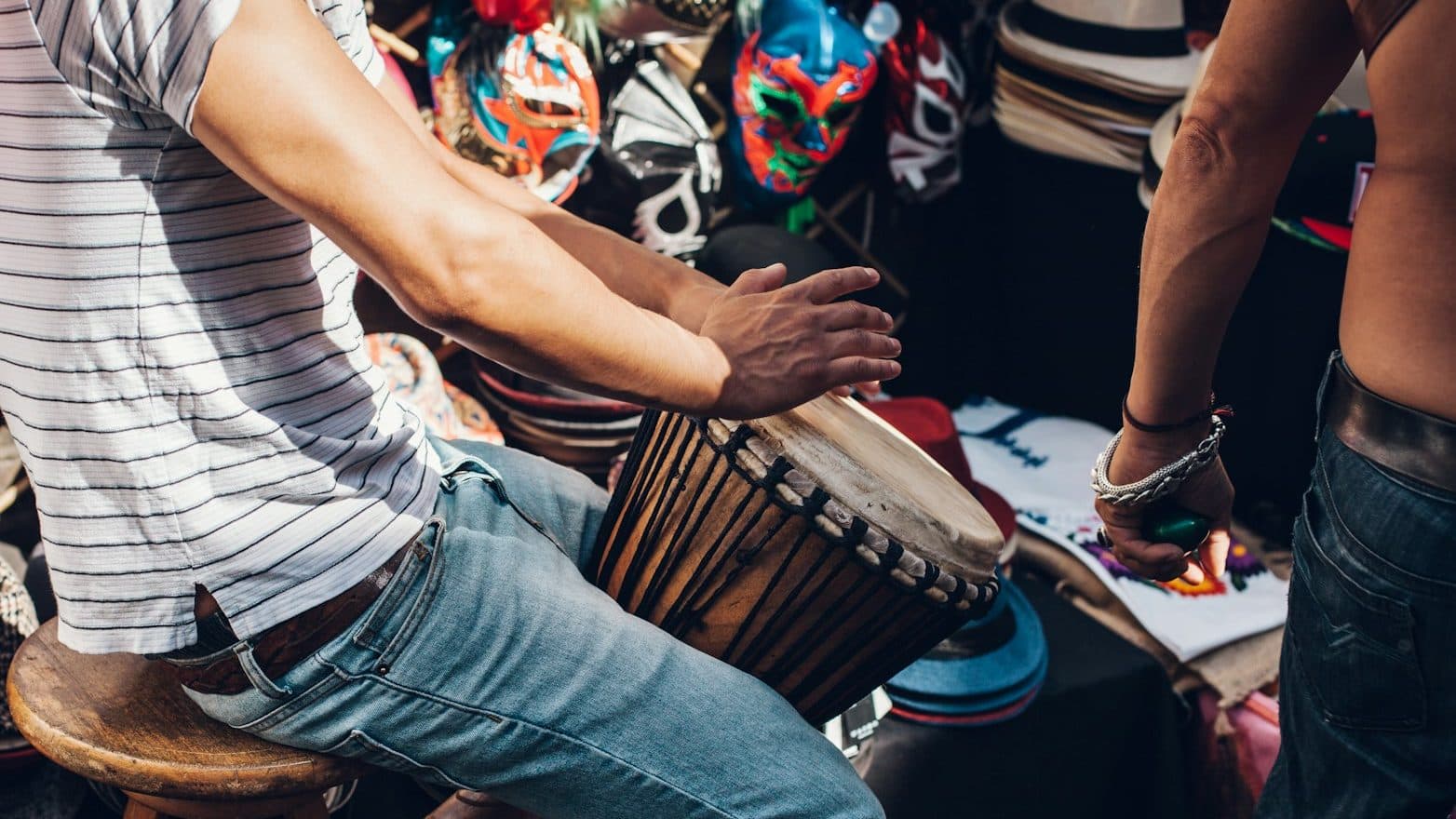 men wearing white striped shirt playing djembe